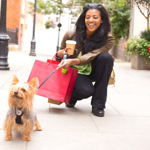 Smiling woman with a yorkie dog on a leash
